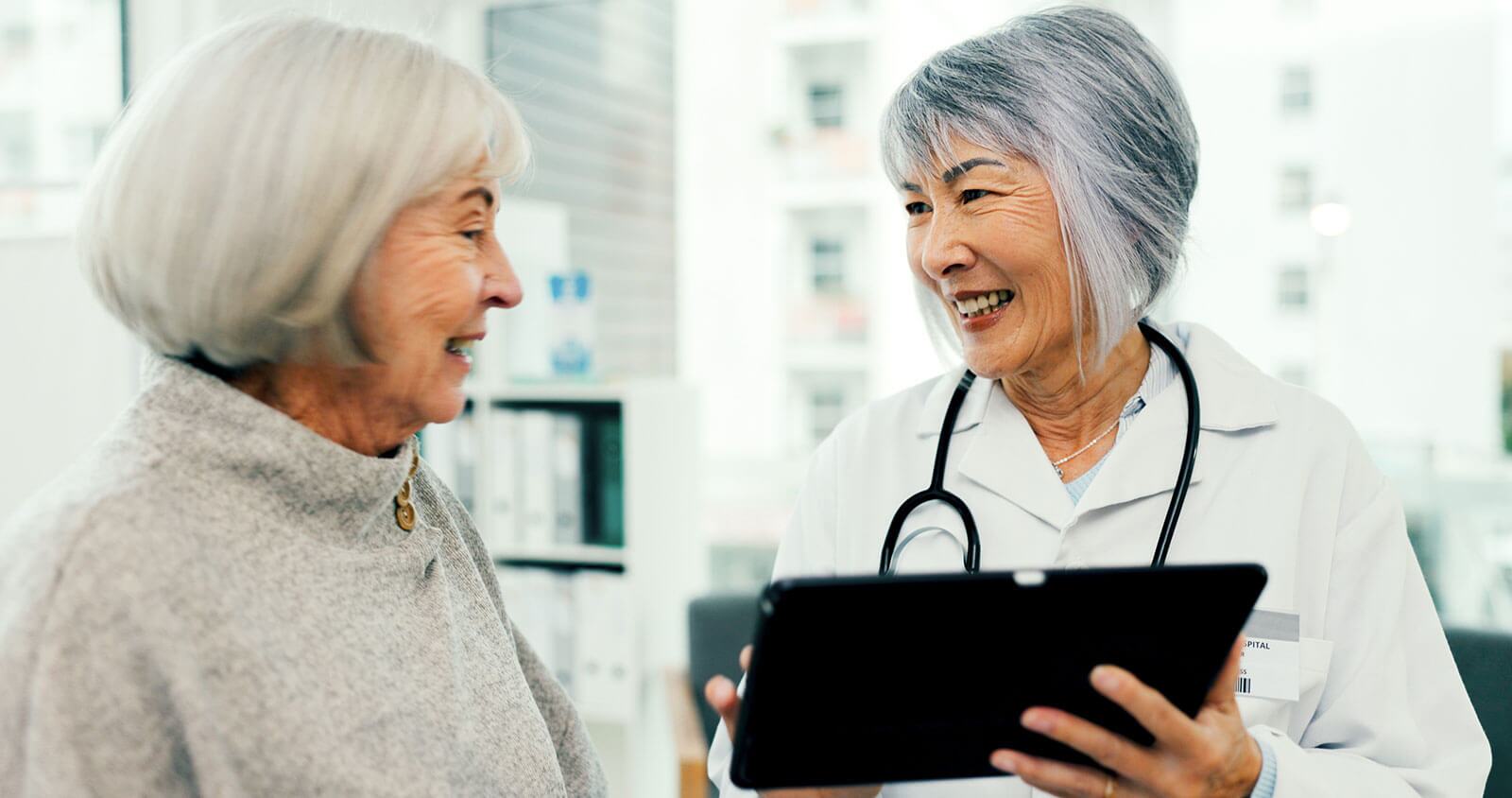 Female doctor smiling and talking to her female patient.