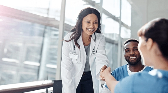 Young female doctor greeting a group of nurses.