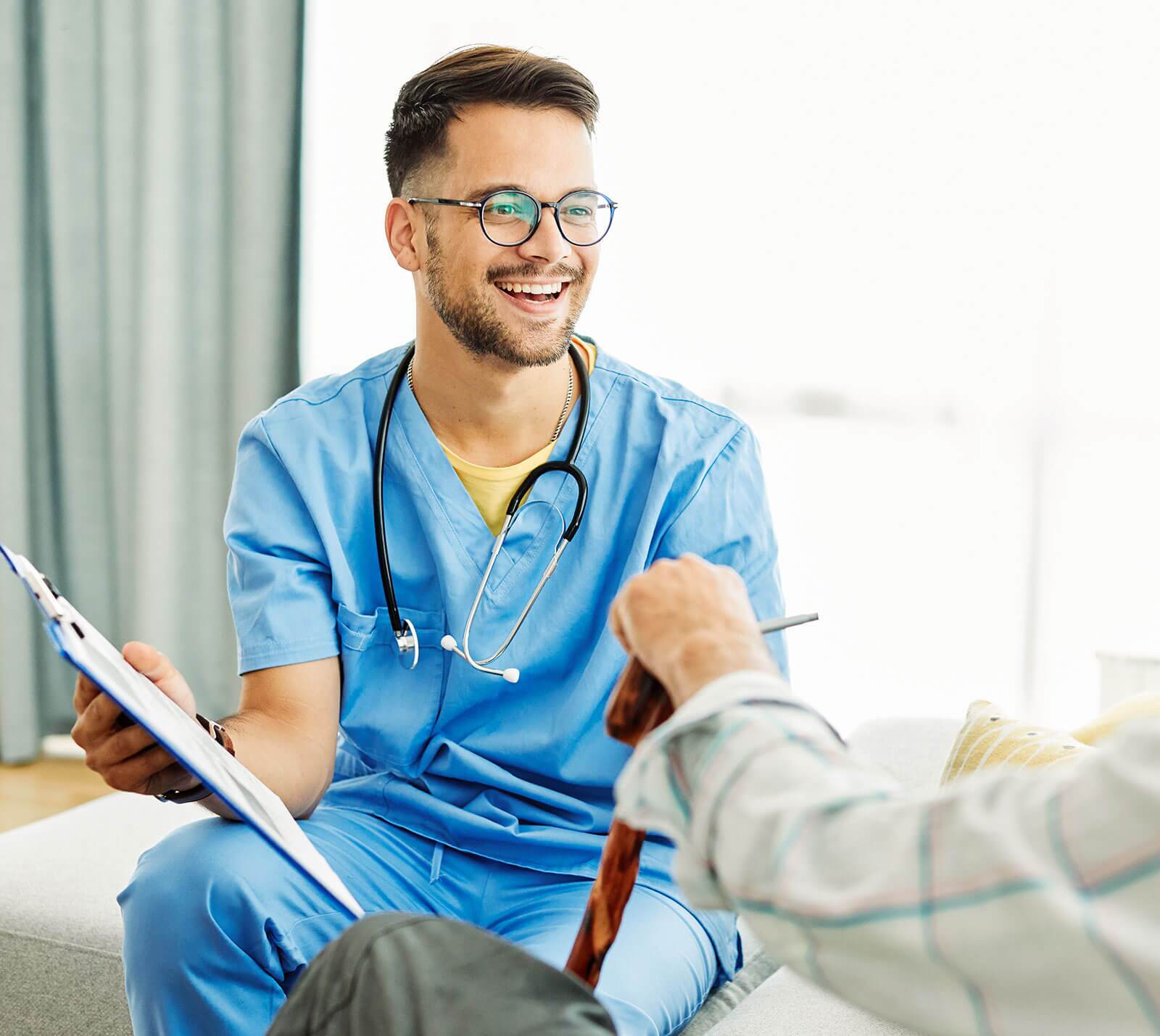 Male doctor sitting and talking with an elderly patient.